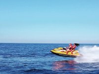 Pareja acelerando en la moto de agua