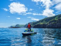  Standing by jet ski next to the cliffs 