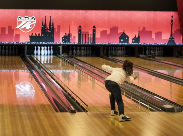 Nina jugando a los bolos