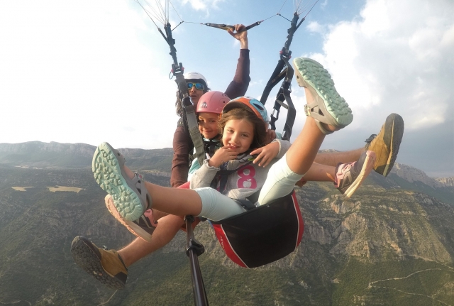 Niñas volando en parapente con el monitor