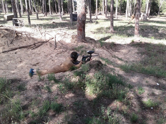 Jugador de paintball a ras de suelo
