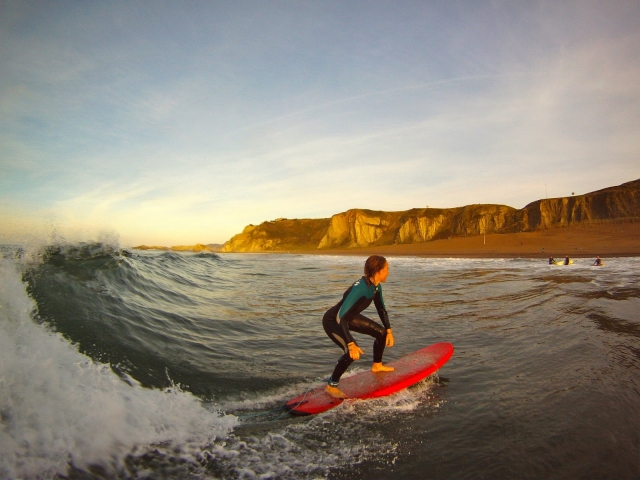 Alumno cogiendo una ola 