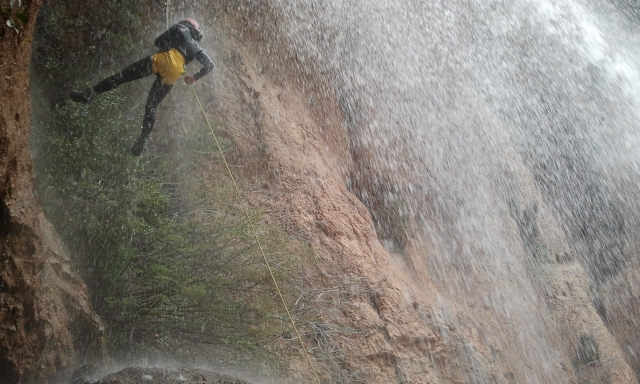 Rapel en la lluvia de una cascada