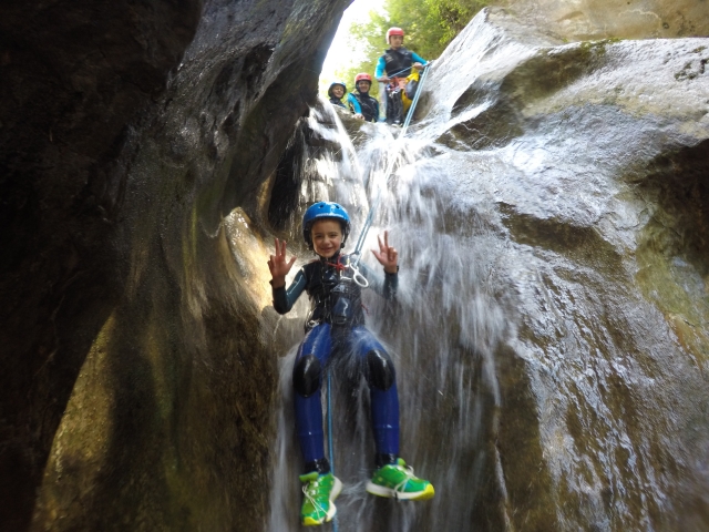  Kleiner Junge sitzt darin der Wasserfall 