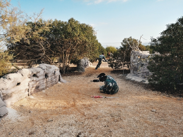 Agachado detras de los sacos de arena