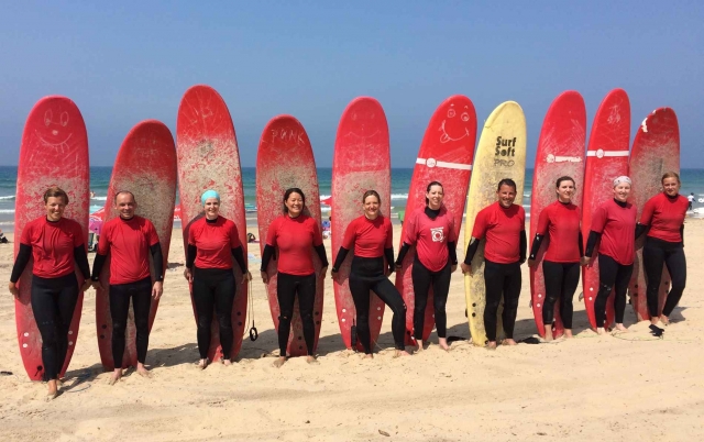 Alumnos con tablas de surf de pie en Conil