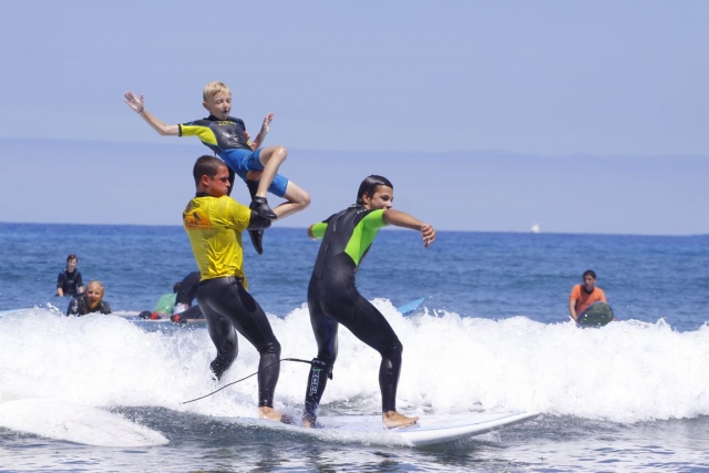  3 ragazzi che fanno surf 