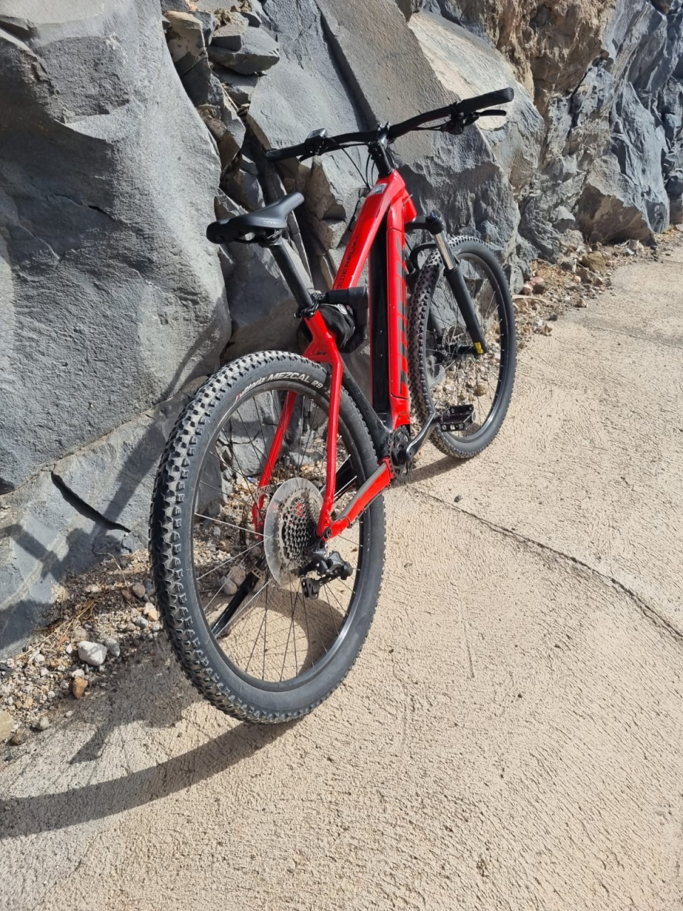 Bicicleta eléctrica de montaña roja sobre las rocas