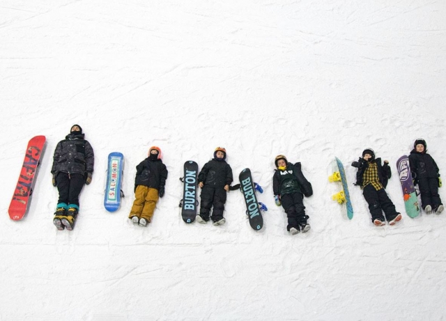 Peques y profesor tumbados en la nieve