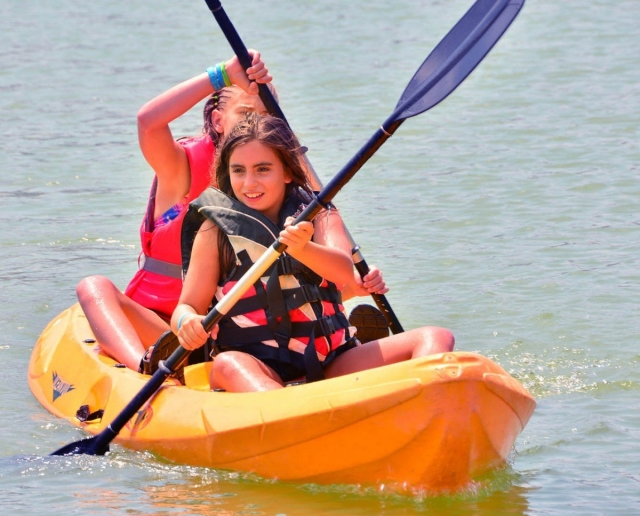 Alumnas del campamento remando en el kayak