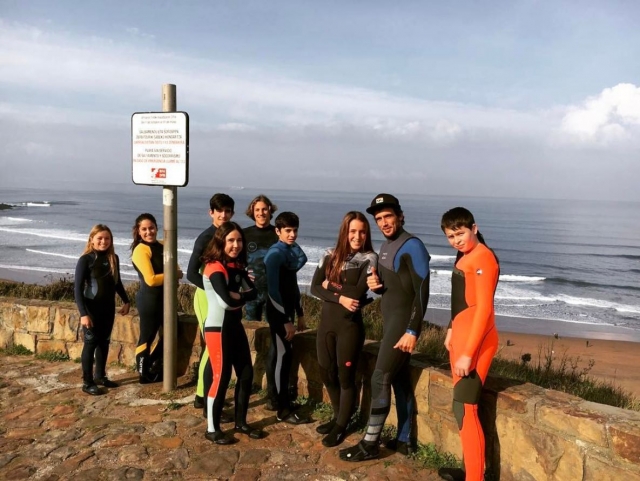 Alumnos de surf junto a la costa