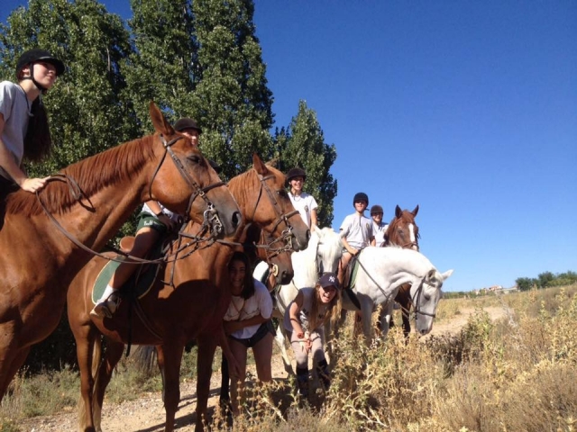 Montados en caballos pardos y blancos