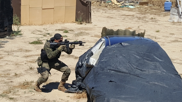 Soldado apuntando mientras se protege