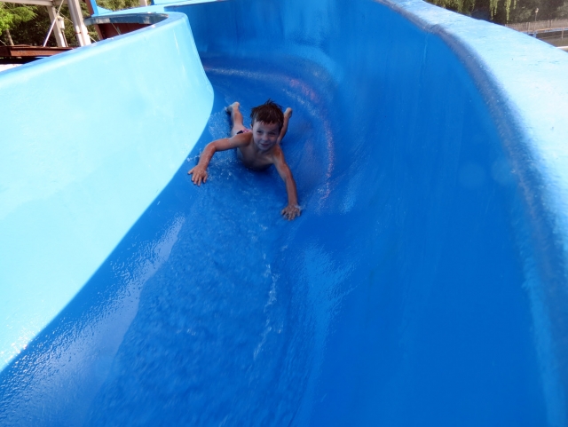  child jumping down a pool slide.JPG 