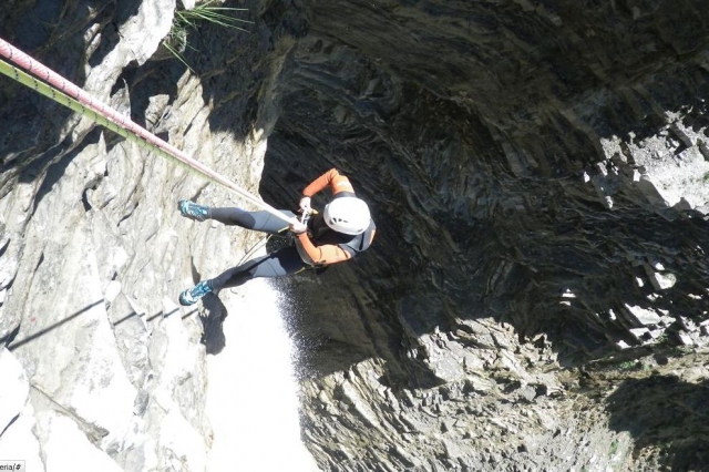  un homme glissant avec une corde sur un terrain montagneux 