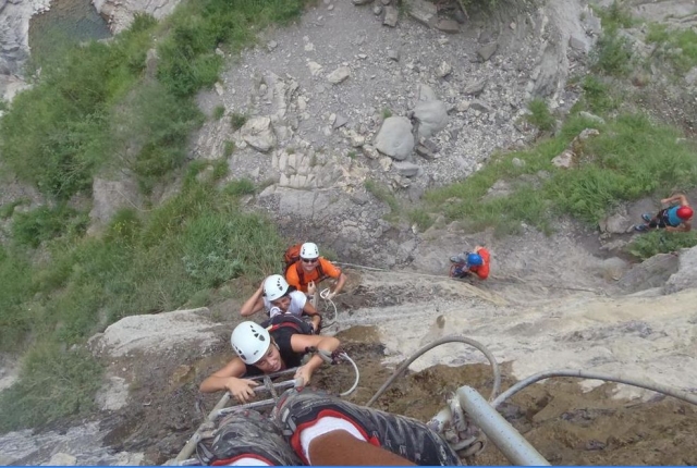  trois personnes escaladant une échelle de montagne