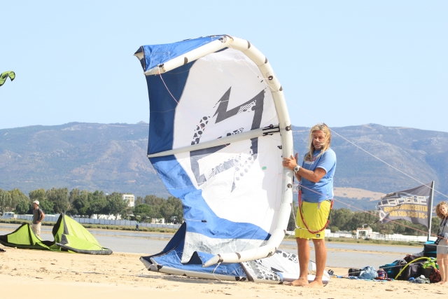 Sosteniendo la cometa en la playa