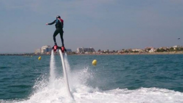  boy with his back practicing flyboarding in the air 
