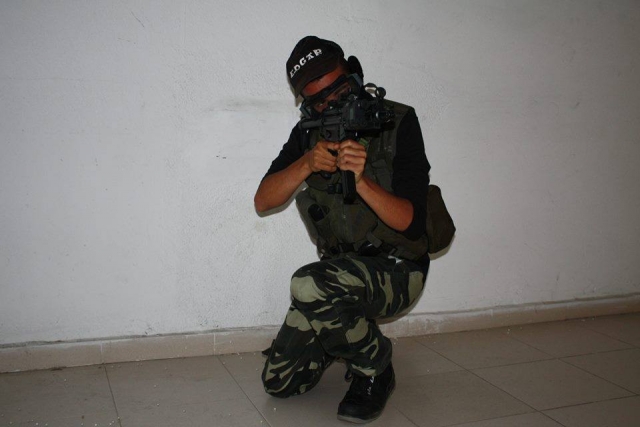  boy crouching with an airsoft replica 