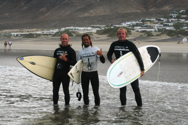 tres surfistas en la orilla.jpg