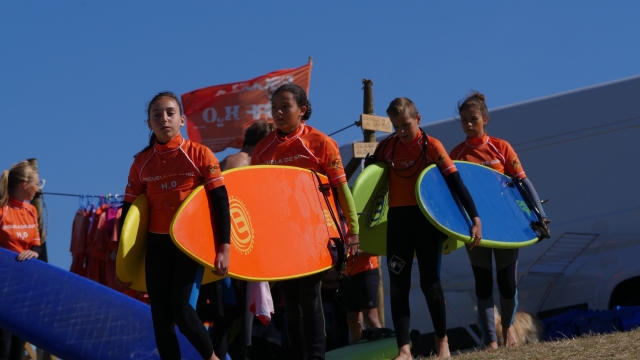  Helfen sich gegenseitig beim Tragen des Bretts - 999 – Dehnübungen vor dem Surfen
