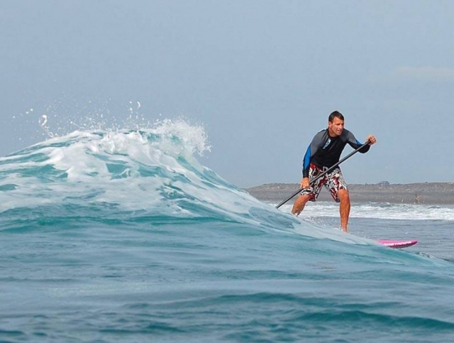 Remando la ola en tabla de sup