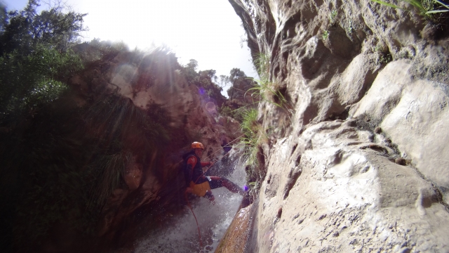 Rapelando apoyado en la roca