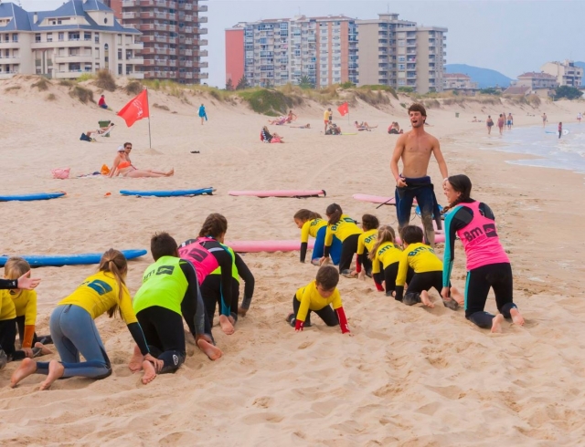  Com os mais pequenos ajoelhados na areia 