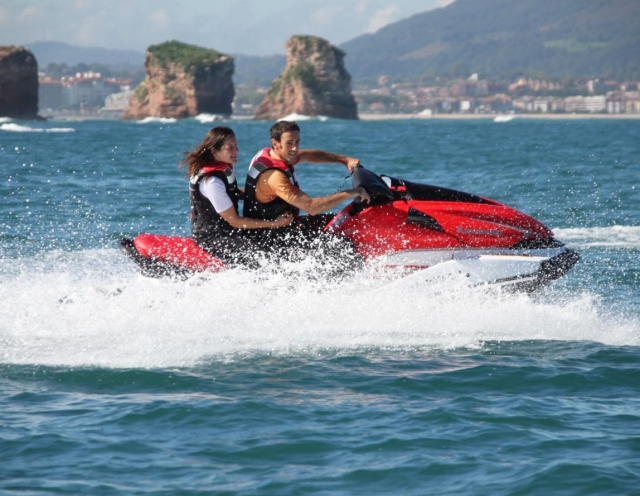  沿着巴斯克海岸乘坐水上摩托艇的情侣 