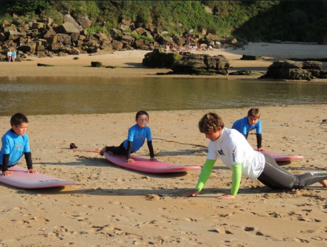 Leccion de surf infantil en la arena