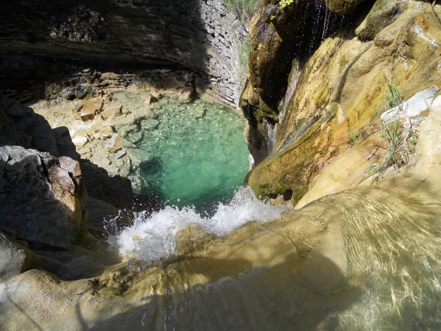Poza turquesa bajo la cascada