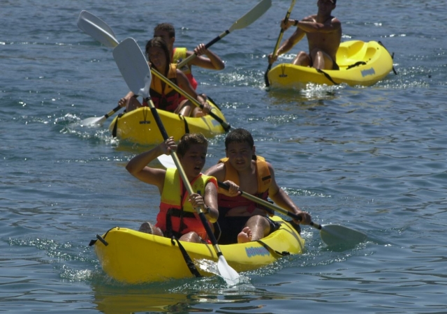 Chicos remando en kayak doble