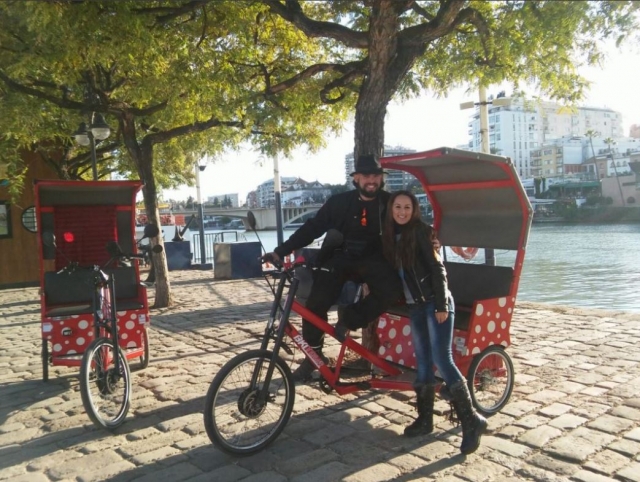 Triciclo y pareja bajo el arbol