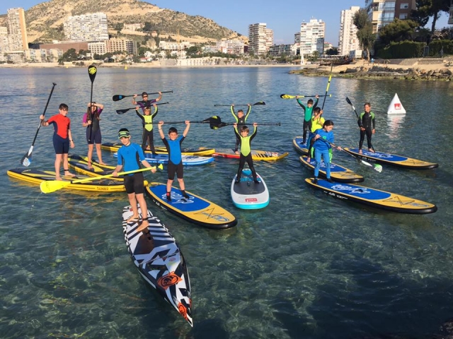 Alumnos con tablas de sup en el mar