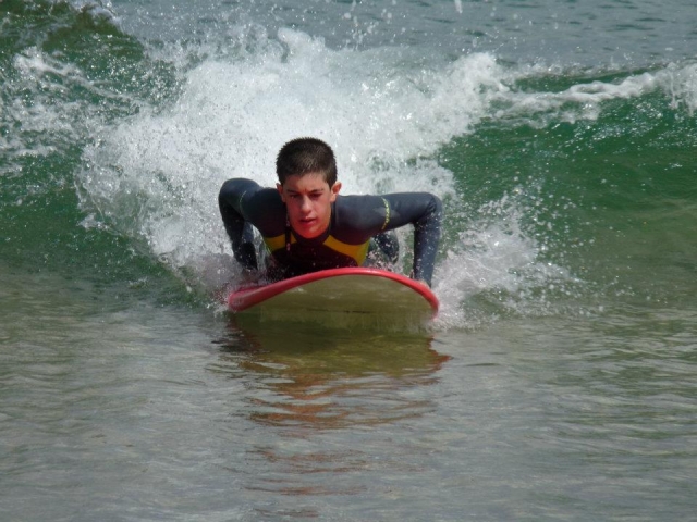 Tumbado en la ola sobre la tabla