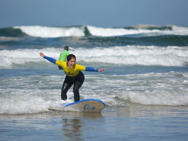 Alumna de surf abriendo los brazos
