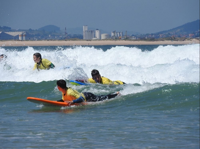 Tumbados en las tablas delante de la ola