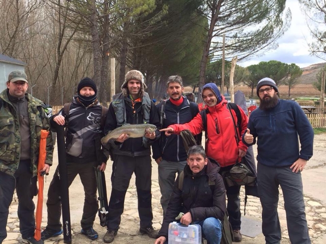  Gruppe von Freunden, die im Winter am See angeln 