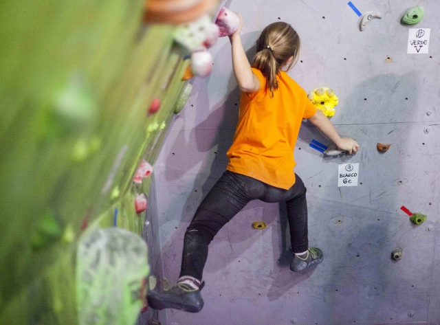 Junger Kletterer an der Kletterwand 