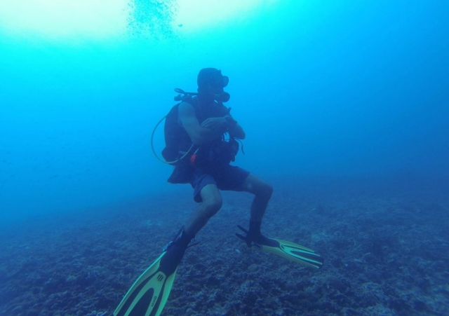 Buzo sumergido cruzando los brazos