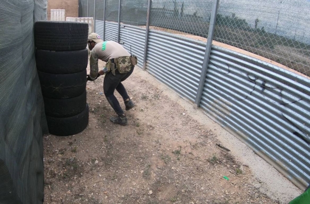 Jugador de airsoft tras los neumaticos
