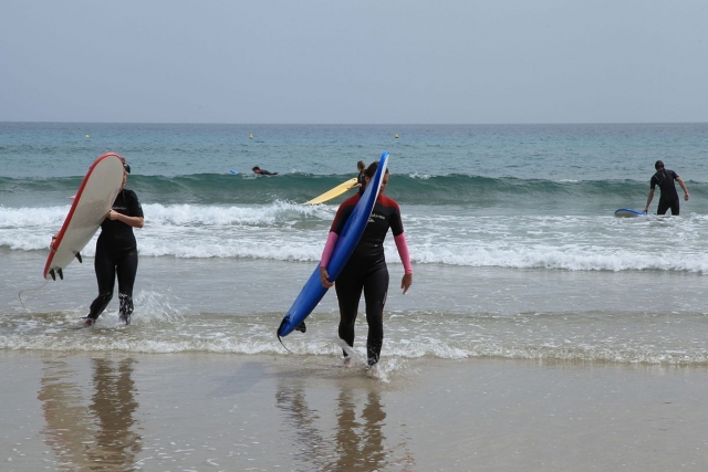 Surfistas saliendo del agua
