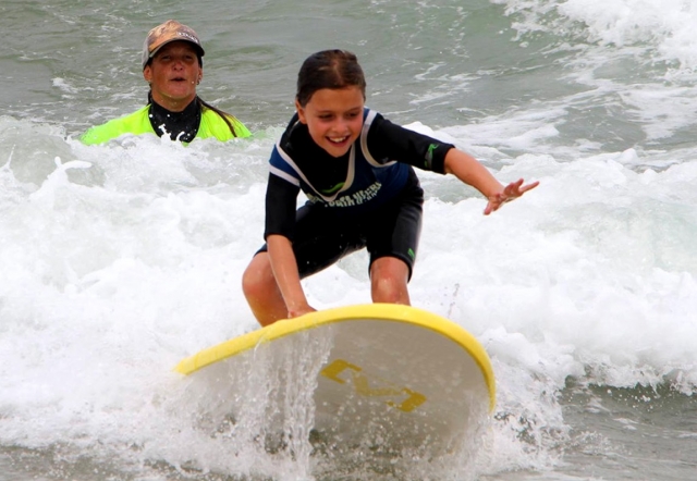  instrutor e criança sorrindo Taxa de surf 