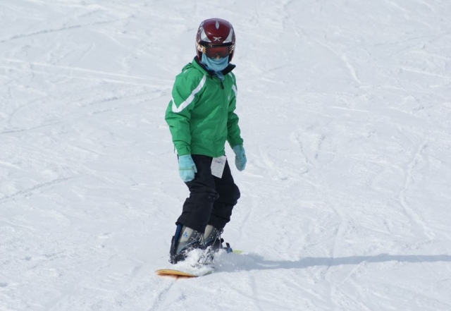 Asolescente haciendo snowboard