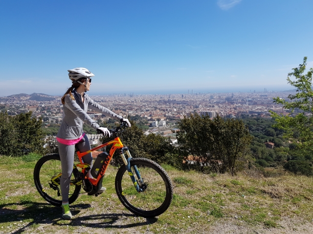 Chica observando las vistas subida a una bici