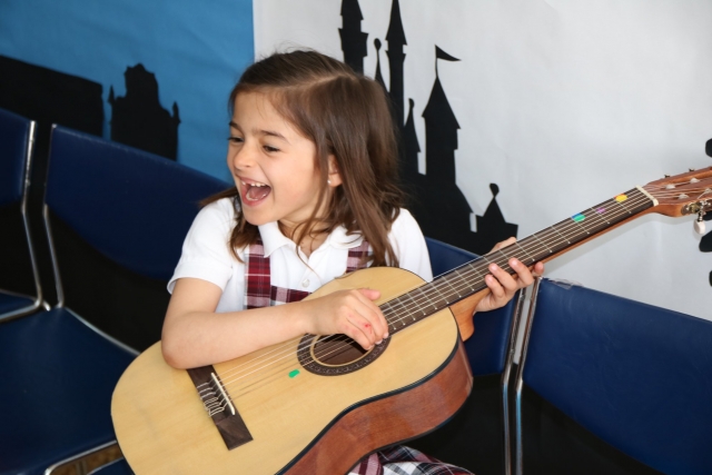 Niña practicando con la guitarra