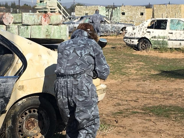  Protecting oneself behind the car in the paintball game 