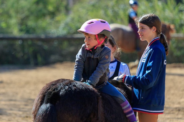  Girl riding on the back of a pony 