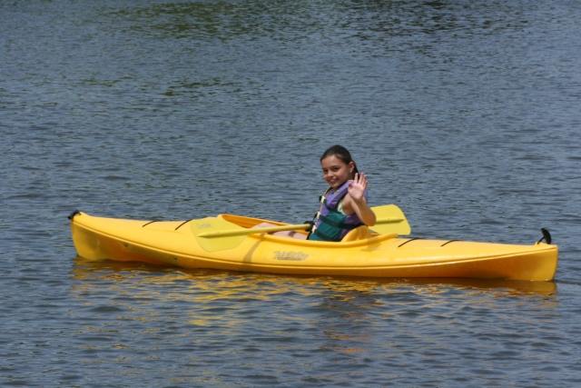 Joven saludando desde el kayak