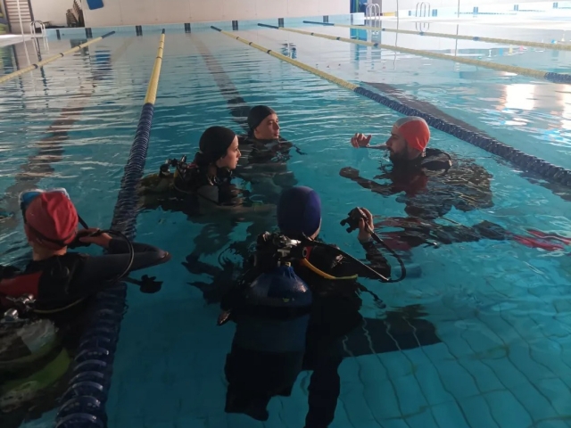 Junto al instructor de buceo en la piscina